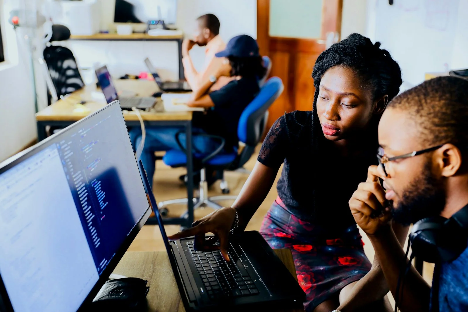 Two professionals reviewing work together on a computer